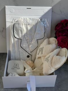 a white box with some shoes and flowers