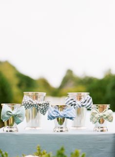 four glasses with bows are sitting on a table