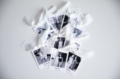 several polaroid photos are laying on top of some white fabric and one has been cut into smaller pieces