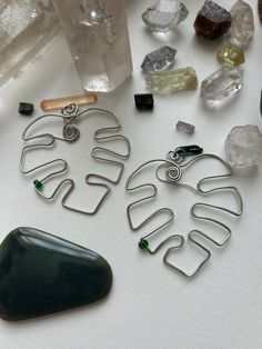 several pieces of metal sitting on top of a table next to rocks and glass bottles