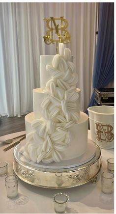 a three tiered white wedding cake with gold decorations