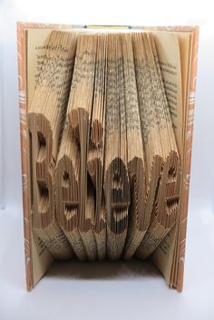 an open book with the word love spelled out on it and folded in two sections