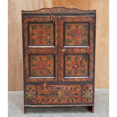 an old wooden cabinet with painted flowers on it