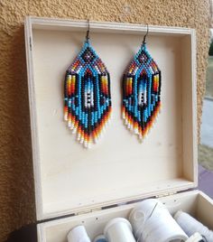 Cherokee Style Pattern Earrings inspired by Native Americans, designed by me. Big Earrings made in colorful blue and traditional fire colors. Beaded out of Superior Selected Czech Seed Beads in sky blue, orange, yellow, white and black colors with feather and diamonds shapes. https://www.etsy.com/listing/683268030/cherokee-style-native-america-inspired?ref=shop_home_active_32&frs=1 Handmade Southwestern Blue Beaded Earrings, Artisan Multicolor Beaded Earrings For Gift, Southwestern Blue Earrings For Gift, Blue Southwestern Style Earrings For Gift, Traditional Blue Beaded Earrings As Gift, Artisan Blue Beaded Earrings As Gift, Handmade Southwestern Multicolor Earrings, Diamonds Shapes, Native Beading