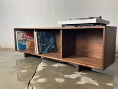 a record player sitting on top of a wooden shelf