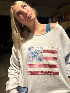 a woman wearing a sweatshirt with an american flag on it