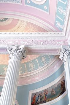 the ceiling is painted in pastel colors and has columns with paintings on them,