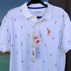 U.S. Polo Assn Polo White With Allover Colorful Polo-Playing People Orange Uspa Embroidered Logo On Chest 2-Button Placket, White Buttons (Extra Included) White Knit Collar And Cuffs Men's Size Large (L) (Check Measurements) Chest (Pit To Pit) 22 Inches Length 30 Inches New With Tags Uspa Polo Tshirt Men, Casual Polo Collar Top With Graphic Print, Multicolor Polo Collar Top With Graphic Print, Summer Polo Collar Top With Graphic Print, Graphic Print Polo Collar Top For Summer, Multicolor Graphic Print Polo Collar Top, Multicolor Graphic Print Top With Polo Collar, White Summer Polo Collar Top, Summer Graphic Print Top With Polo Collar