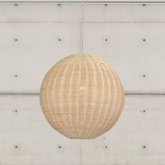 a light that is hanging from the ceiling in front of a wall with white bricks