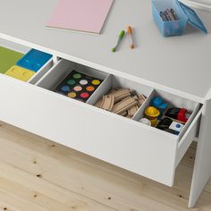 a white desk with drawers filled with art supplies