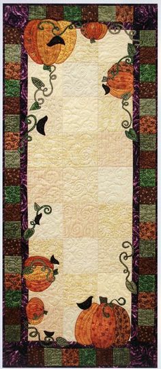 a quilted table runner with pumpkins on it