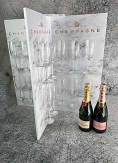 two champagne bottles and one empty wine glass