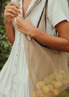 a woman holding a bag full of apples