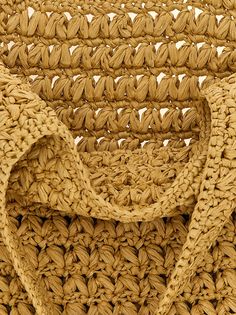 a close up view of the handles and straps of a woven basket bag, which is made out of straw