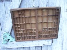 an old wooden box with holes in it sitting on the side of a building next to a door