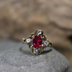 1950's Beautiful 1950's Vintage Deco Ruby Topaz Ring 10K Solid Gold Ruby White Topaz Ring 2.9 Grams Size 6 1tcw Ruby Engagement Ring Vintage Gold Ruby Rings 10K This is a stunning ruby ring, 1tcw ruby & white topaz ring in solid 10K yellow gold 1950's The face of the ring measures 1/2 x 5/8" The center ruby is 1tcw and measures 3/16 x 5/16" There are 4 small white topaz that surround the face of the ring, and they are 1/8tcw each one  Size 6 weight 2.19grams Stamped 10K (solid yellow gold) Makers marks Great vintage condition, beautiful ruby topaz ring Great looking ring. Please look at all photos as they are part of the description. Please note the ring is shipped out unpolished. Thanks for stopping by Red Ruby Engagement Ring, Vintage Gold Cluster Ring With Gemstones, Vintage Yellow Gold Ring With Center Stone, Antique Gemstone Cluster Ring For Anniversary, Victorian Gemstone Cluster Ring For Wedding, Vintage Oval Sapphire Birthstone Ring, Antique Ruby Diamond Ring With Center Stone, Vintage Oval Sapphire Ring As Birthstone, Victorian Gemstone Cluster Wedding Ring