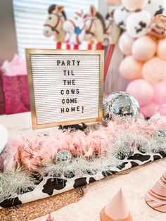 a party table with pink and white decorations, balloons and a sign that says party til the cows come home