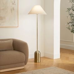 a living room scene with focus on the floor lamp and couch in the foreground