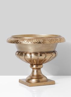 a golden bowl sitting on top of a white table