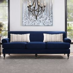 a living room with a blue couch and chandelier