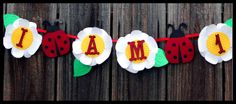 a ladybug banner with the word i am on it hanging from a wooden fence