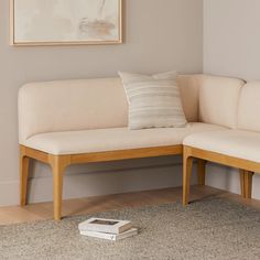 a white couch sitting on top of a hard wood floor next to a book shelf