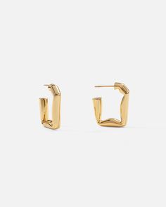 The much-loved classic hoops get an edgy upgrade with these folded rectangular hoop earrings, an ode to simplistic style statements using deconstructed geometry. Slim posts give this subversive-basic design effortless wearability, perfect for your newest Ear Party look.

Size: 24.5x22mm
Material: 18k Gold Plated On Brass Cheap Trendy Rectangular Hoop Earrings, Luxury Rectangular Hoop Earrings In Classic Style, Miao Silver, Simplistic Style, Ear Party, Cotton Gloves, Open Hoop Earrings, Basic Design, Party Look