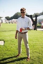 a man standing on top of a lush green field holding a red cup in his hand