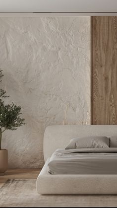 a large bed sitting next to a plant in a bedroom