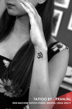 a woman with a small tattoo on her left arm and the word tattoo by prnali