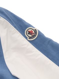 Moncler light blue Kobby bomber jacket for children with contrasting front buttoning, slanted pockets, elastic hem with web stripes, contrasting under sleeve, logo plate on the sleeve.Composition: 100% COTTON SLEEVES 100% POLYAMIDE 1 MATERIAL 100% POLYAMIDE INTERIOR LINING 100% POLYESTER White Sporty Outerwear With Logo Detail, White Long Sleeve Outerwear With Logo Patch, Sporty White Outerwear With Logo Detail, Blue Long Sleeve Outerwear With Logo Patch, Casual Blue Outerwear With Logo Patch, Sporty White Outerwear With Striped Cuffs, Sporty Light Blue Cotton Outerwear, White Cotton Outerwear With Striped Cuffs, Adventure Accessories