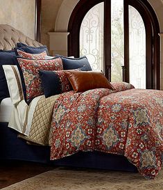 a bed in a bedroom next to a window with an arched doorway and rug on the floor