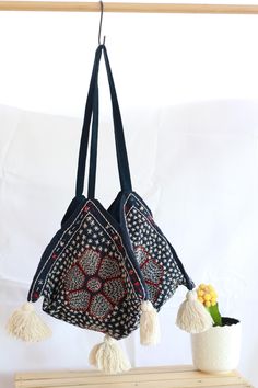 This handmade shoulder bag is a true piece of art, featuring intricate hand-stitching a unique bohemian design, and a four-sided (tetrahedral) base, giving it a distinct and geometric look. Crafted with care by our artisans. This bag is perfect for anyone who loves unique and beautiful accessories.  With its charming tassels and original design, this bag is sure to be a standout addition to any wardrobe. Unique Design: Every bag boasts a distinct pattern, with subtle variations in details, makin Bohemian Handheld Hobo Bag, Bohemian Blue Hobo Tote Bag, Handmade Rectangular Shoulder Bag For Festivals, Handmade Tote Shoulder Bag For Festivals, Blue Tote Hobo Bag For Festivals, Bohemian Rectangular Hobo Bag, Artisan Hand-stitched Festival Bags, Traditional Handmade Tote Shoulder Bag, Traditional Handmade Hobo Tote Bag