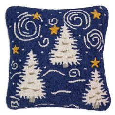 a blue pillow with white trees and stars on the front, against a white background