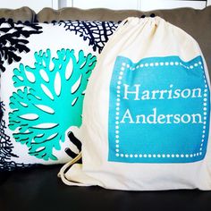 two personalized pillows sitting on top of a couch next to a bag with the name harrison anderson