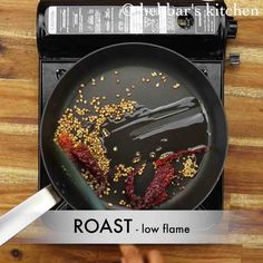 a person holding a frying pan with food on it and the words roast low flame