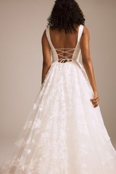 a woman in a white wedding dress looking back