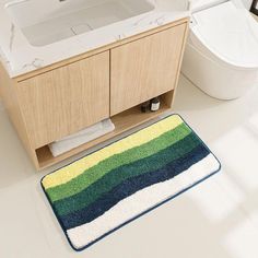 a white toilet sitting next to a bath tub in a bathroom under a sink vanity