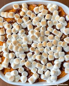 sweet potato casserole with marshmallows in a white dish on a wooden table