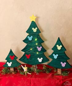 three wooden christmas trees with mickey mouse heads on them