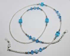 "A lovely glasses chain made using blue tones crystal and glass beads. The glasses chain measures approximately 28\" in length and is finished with rubber ends to securely attach your reading glasses or sunglasses.  Very striking and beautiful chain. Lovely gift idea. Wrapped in tissue paper and presented in an organza pouch." Blue Beaded Chain Glasses Chains With Round Beads, Blue Beaded Glasses Chains, Blue Glasses Chains With Round Beaded Chain, Blue Beaded Glass Glasses Chains, Blue Glass Necklaces With Adjustable Chain, Adjustable Blue Glass Beaded Necklaces, Blue Glass Faceted Beads, Blue Faceted Glass Beads, Blue Glass Beaded Chain Jewelry