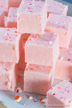 several pieces of pink fudge cake sitting on top of a white plate with sprinkles