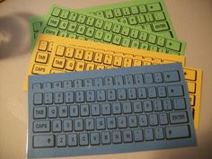 three different colored keyboards sitting next to each other on top of a white table with a computer mouse