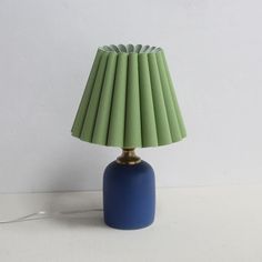 a blue table lamp sitting on top of a white counter next to a light bulb