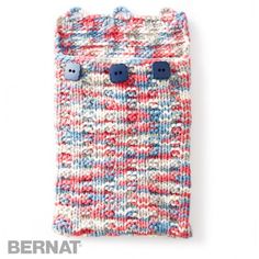 a red, white and blue knitted bag with buttons on the front is shown