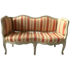 an old fashioned couch with striped upholstered fabric