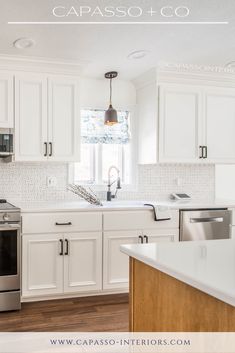 a kitchen with white cabinets and stainless steel appliances