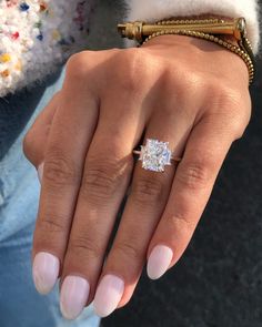 a woman's hand with a diamond ring on it