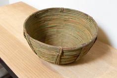 a woven basket sitting on top of a wooden table