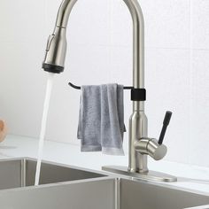 a kitchen faucet that is running water from the faucet to the sink